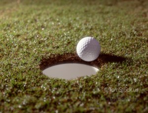 Golf ball at edge of hole